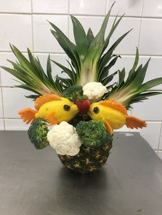 a pineapple decorated with broccoli, cauliflower and other vegetables in the shape of chickens