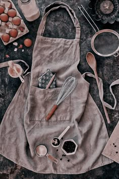 an apron with utensils, eggs and other kitchen items laid out on a table