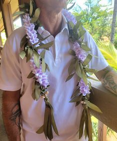 a man wearing a lei with flowers around his neck