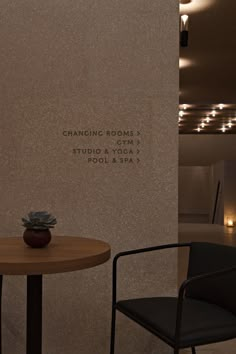 two chairs and a table in front of a wall with the words changing rooms on it