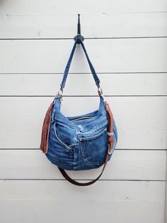 Cool lee jeans rearranged to this cool hobo bag. dark blue jeans in classic style.  2 handles, one shorter denim handle and one longer leather handle. leather handle on this bag can be adjusted and removed with hummer clasps.  Smaller rounded hobo bag. A hobo bag ready to be filled up for your everyday adventures.  5 pockets on the outside, one with zipper  brown leather belt reused into handle. can be adjusted  fabric inside with 4 pockets Fabrics? Blue levis jeans on the outside. mustard yellow cottonmix fabric as inner lining, once a curtain.   Size? Width 40cm/16" Lenght 32cm/12,5" denim handle is 60 cm  leather strap is  113 cm at the most, can be adjust to shorter.  Last pic is for size and style reference.  A very lovable bag! Blue Levis Jeans, Bag Jeans, Denim Shoulder Bag, Style Reference, Denim Shoulder Bags, Bag Dark, Everyday Adventures, Dark Blue Jeans, Brown Leather Belt