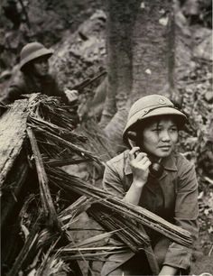 an old black and white photo of a boy talking on a cell phone in the woods