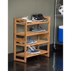 three tiered wooden shoe rack with two pairs of shoes on top and one pair of sneakers below