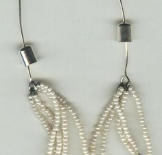 two strands of white pearls are attached to silver earwires with metal clasps