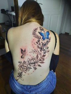 the back of a woman's shoulder with flowers and butterflies on her left side