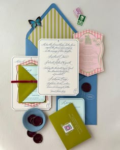 the wedding stationery is laid out on top of each other, including envelopes and cards