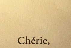 the word cherie written in black ink on a white paper with brown writing underneath it