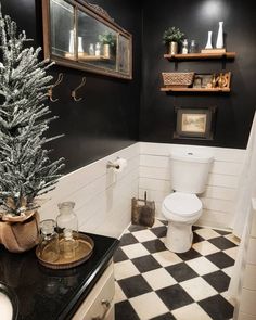 a black and white bathroom with a christmas tree on the counter next to the toilet