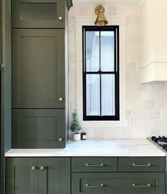 a kitchen with green cabinets and white counter tops