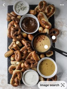 an assortment of pretzels and dipping sauces on a platter