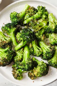 broccoli florets are arranged on a white plate