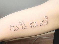 a woman's arm with three small dinosaurs on it