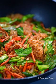 stir fried vegetables are being cooked in a wok