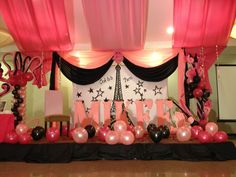 a decorated stage with balloons and decorations for a paris themed party