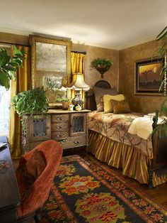 a bedroom with a bed, desk and chair in it next to a large potted plant