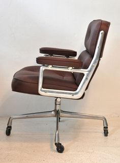 a brown office chair sitting on top of a metal base