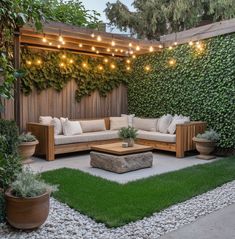 an outdoor living area with couches, tables and lights