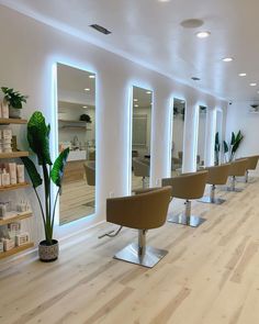 a row of chairs sitting in front of mirrors