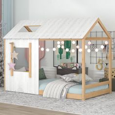 a child's bed with a white roof and lights hanging from the ceiling above it