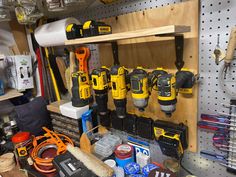 a workbench with many tools on it in a garage or repair shop, including drillers and screwdrivers