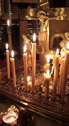 many lit candles are on a table with other items in front of the candle holders