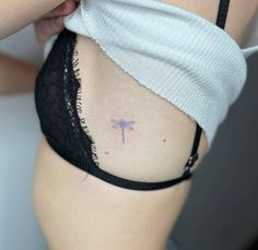 a woman with a small dragonfly tattoo on her stomach