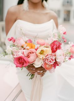 a woman holding a bouquet of flowers in her hands