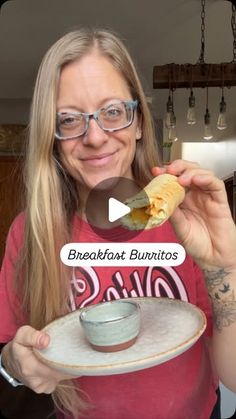 a woman holding a plate with food on it and the caption reads breakfast burritos