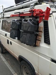 the back end of a white van with luggage strapped to it's roof rack