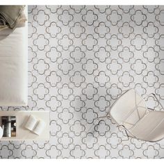 an overhead view of a bedroom with white and gray wallpaper, bedding, and chair