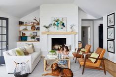 two women are sitting in the living room with their dog on the floor next to the fireplace