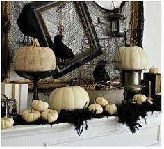 a mantle decorated with black and white pumpkins