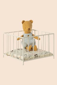 a stuffed teddy bear sitting in a crib