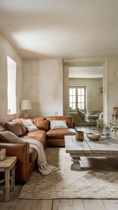 a living room filled with furniture and a fire place next to a table on top of a hard wood floor