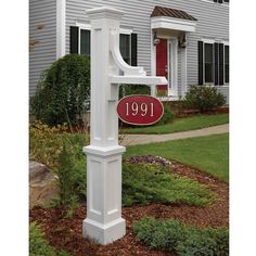 a white mailbox with a red sign in front of a house