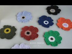 crocheted flowers are arranged on a white surface