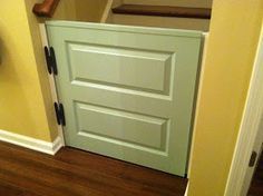 an open door in the corner of a room next to a stair case with a clock on it