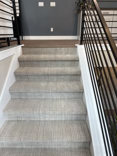 a staircase with gray carpet and black railings