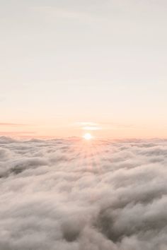 the sun is setting over some clouds in the sky