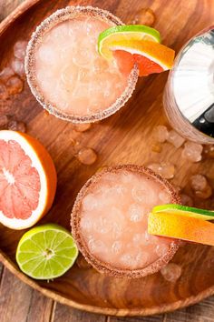 two grapefruit margaritas on a wooden plate