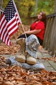 a woman sitting on a porch with an american flag and boots in front of her