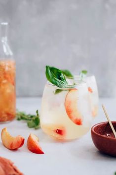 two glasses filled with drinks and garnished with basil