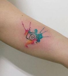 a person's arm with a camera on it and watercolor splatters