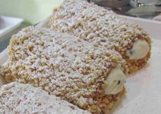 some type of dessert sitting on top of a white plate covered in powdered sugar