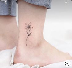 a small flower tattoo on the ankle