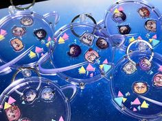 several key chains with cartoon faces on them are hanging from clear acrylic rings