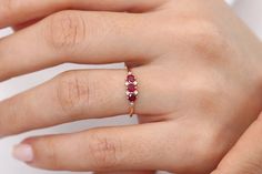 "14k Gold Ruby Ring / Dainty Ruby Ring / Ruby Stacking Ring / Natural Ruby / Promise Ring / Ruby and Diamond Ring / Statement Ring Ferkos Fine Jewelry Features ✔Made to Order ✔Gold Kt: 14K (also available in 18K) ✔Available Gold Color: Rose Gold, Yellow Gold, White Gold ✔Round Ruby: 3 pcs 3.0 MM ✔Round Diamond: 6 pcs 1.2 MM ✔Number of Stones: 9 ✔Ruby CTW: 0.33 ctw ✔Diamond CTW: 0.04 ctw ✔Ready to Ship in 7-10 Business Days ★ ★ ★ Each order will be beautifully packaged for gift giving in a jewelr 14k Gold Three Stone Ruby Promise Ring, 14k Gold Three Stone Red Rings, Red Three Stone 14k Gold Rings, 14k Gold Three Stone Ruby Ring For Anniversary, Ruby Ring Simple, Ruby Promise Ring, Ruby Ring Designs, Dainty Ruby Ring, 14k Gold Ruby Ring