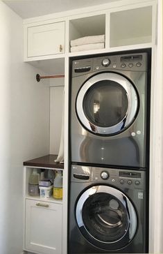 the washer and dryer are stacked on top of each other in this laundry room