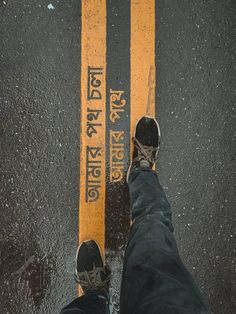 someone standing on the street with their feet up in front of an orange crosswalk