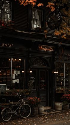 a bike is parked in front of a restaurant with autumn leaves on the ground outside